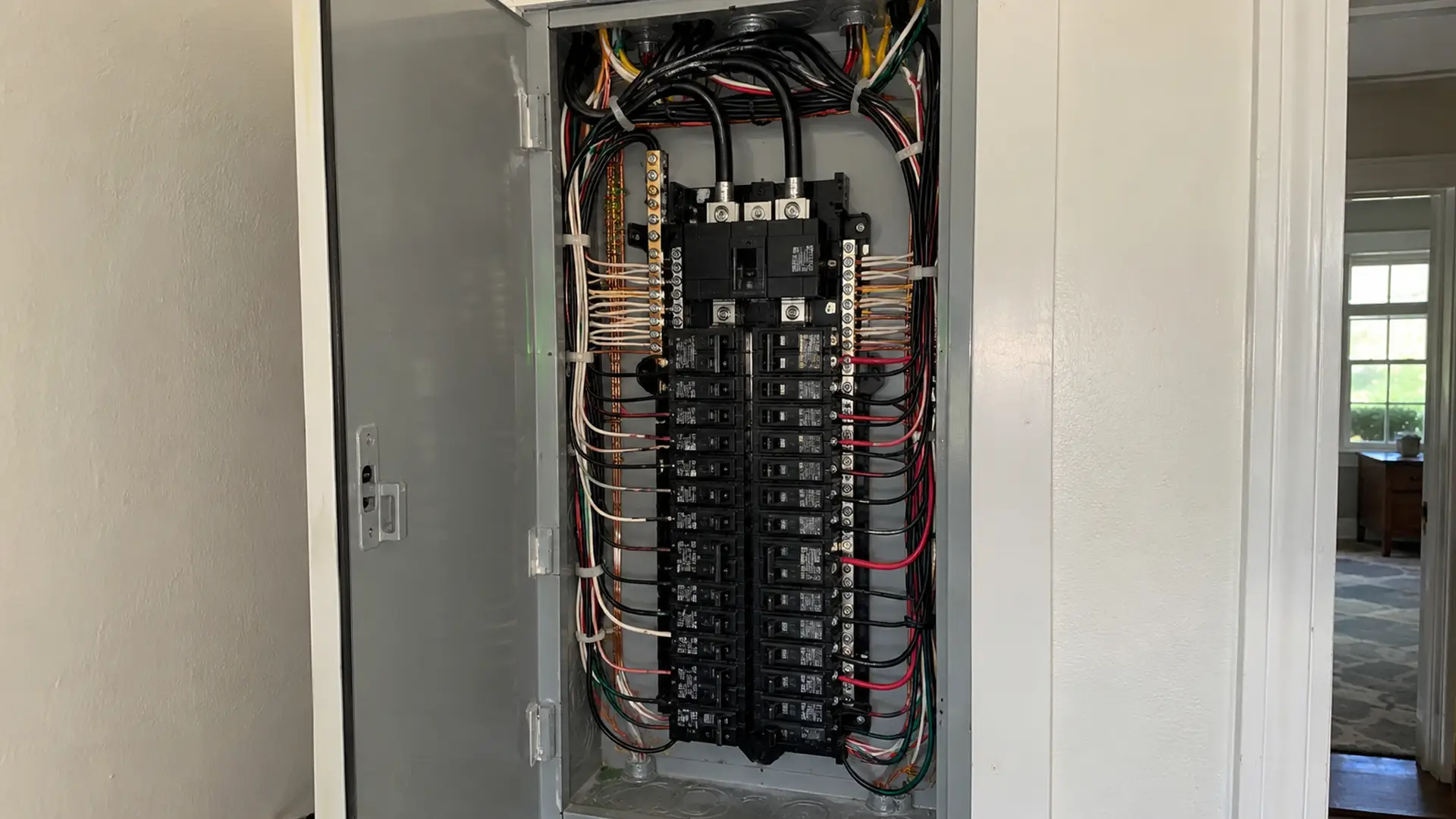 Close-up of circuit breakers and electrical wiring in an open panel